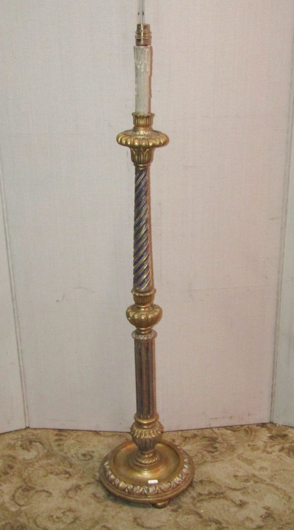 A gilt wood floor standing standard lamp in the form of a candle stand, with partially fluted and