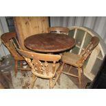 Four Windsor style fiddle back kitchen chairs, together with a circular pine table on turned
