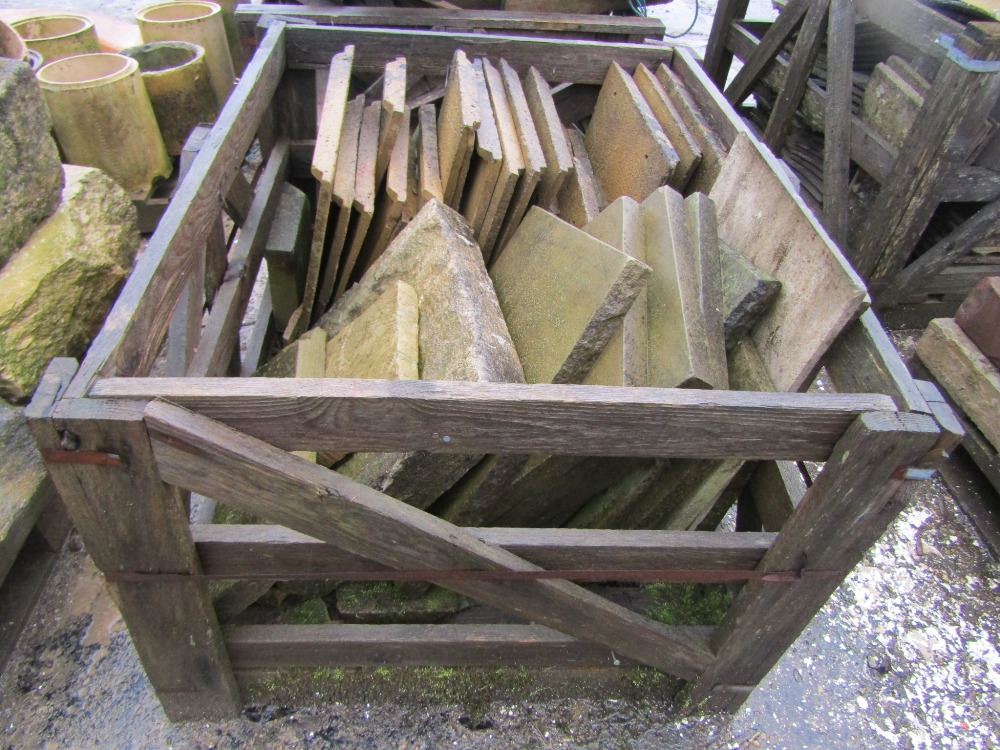 A crate of miscellaneous weathered concrete tiles, various sizes, limestone and other panels