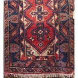 Afghan three medallion rug, decorated with geometric blue motifs upon a red ground, 200 x 120cm