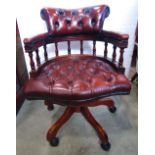 A reproduction captains type swivel desk chair, with button leather upholstered seat and back,