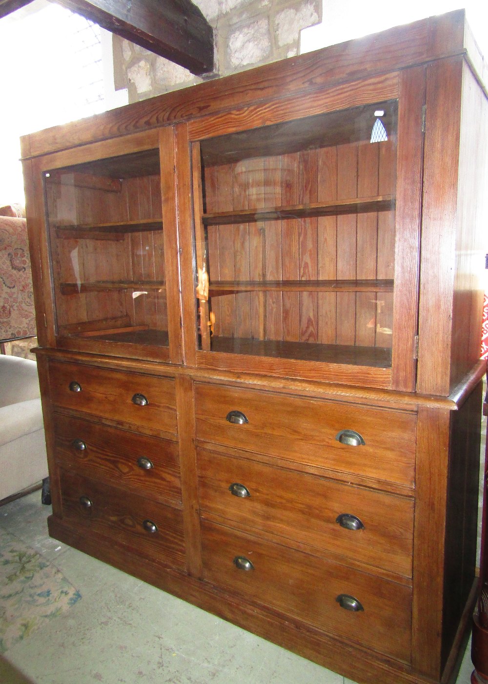 A substantial pitch pine dresser, the upper section enclosed by a pair of rectangular glazed