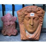 A contemporary terracotta garden wall pocket with female face mask and foliate detail, together with