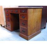 An Edwardian walnut kneehole, twin pedestal writing desk (one piece) with inset writing surface over