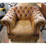 A good quality button back library drawing room chair in pale tan coloured leather and raised on