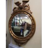 A substantial gilded wall mirror in the Regency style, the circular bevelled edge mirror plate