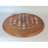 A solitaire board with various antique marbles decorated with interested lattachino glass work,