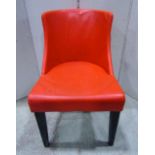 A set of six dining chairs with shaped outline, upholstered in orange stitched vinyl and raised on