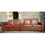 A pair of contemporary stitched brown leather upholstered two seat club style sofas raised on