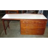 A 1970s teak kneehole desk or workstation, with rectangular formica inset top over an arrangement of
