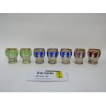Set of seven bohemian glass short drinking glasses with embossed coloured panels and gilt
