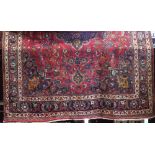 Large Persian Hamadam village carpet with central medallion on a red ground, 350 x 250 cm