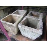 Four weathered cast composition stone garden planters of square tapered form with simulated stone
