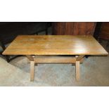 A light oak tavern type table, the rectangular top raised on a pair of X framed supports united by a