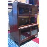 A mahogany floorstanding three sectional library bookcase enclosed by three pairs of rectangular