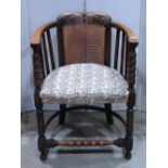 A 1920s tub chair, with stained beechwood frame, cane panelled back with carved detail, slatted open