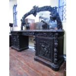 A remarkable Victorian carved oak pedestal sideboard with inverted breakfront form set beneath large