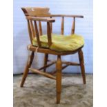 A light elm and beechwood smokers bow elbow chair with turned spindle back, raised on tapered