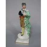 A 19th century Staffordshire figure of a theatrical character in spotted green cloak, possibly