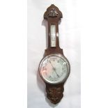 Mid-20th century aneroid barometer/thermometer, with silvered back plates and carved oak detail,