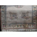 Chinese wool carpet with central medallion pattern and further floral sprays upon a pale ground, 280