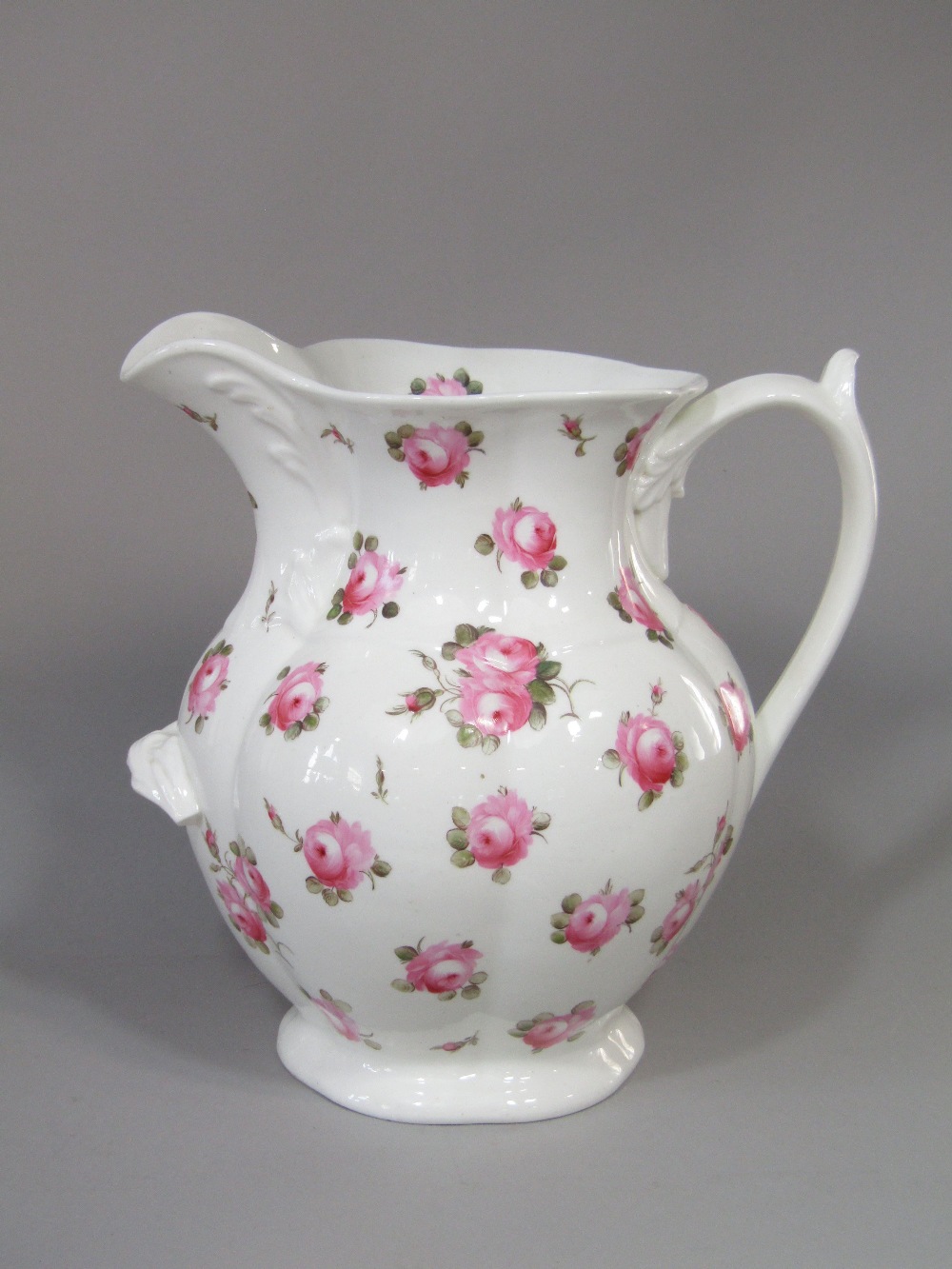 A large 19th century ewer, possibly Coalport, with painted pink rose decoration and supporting