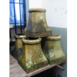 Five matching weathered buff coloured chimney pots of squat octagonal form with impressed
