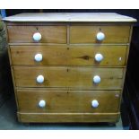 A Victorian stripped pine bedroom chest of two short over three long graduated drawers with