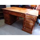 A reproduction Georgian style stripped pine kneehole twin pedestal desk fitted with seven frieze