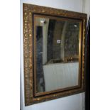 A reproduction wall mirror of rectangular form, the gilt moulded frame with repeating foliate