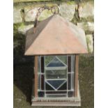 An arts and crafts style copper hall or porch lantern, of square form, enclosing coloured leaded