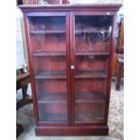 A stained pine side cabinet floorstanding and enclosed by a pair of full length rectangular glazed