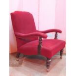 A late Victorian/Edwardian low deep seated open armchair with shaped outline, upholstered finish and