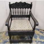 A good quality 19th century Indian ebonised hardwood elbow chair with drop in seat, profusely carved