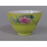 A good quality oriental tea bowl of shaped form with enamelled floral sprigs on a yellow ground with