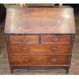 A Georgian oak bureau of two long and two short drawers, the fall flap enclosing a fitted interior