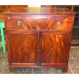 A Georgian mahogany cupboard enclosed by a frieze drawer and a pair of panelled doors raised on