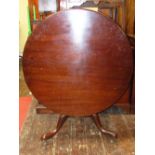 A large Georgian mahogany snap top table, the circular top 110 cm diameter raised on a vase shaped