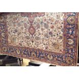 Indian carpet with central floral red medallion, framed by scrolled foliage, upon a fawn ground, 350