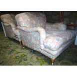A pair of contemporary Howard style low deep seated armchairs with floral patterned upholstery and