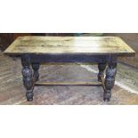 An old English style oak refectory table with a heavy plank top and cleated ends raised on four