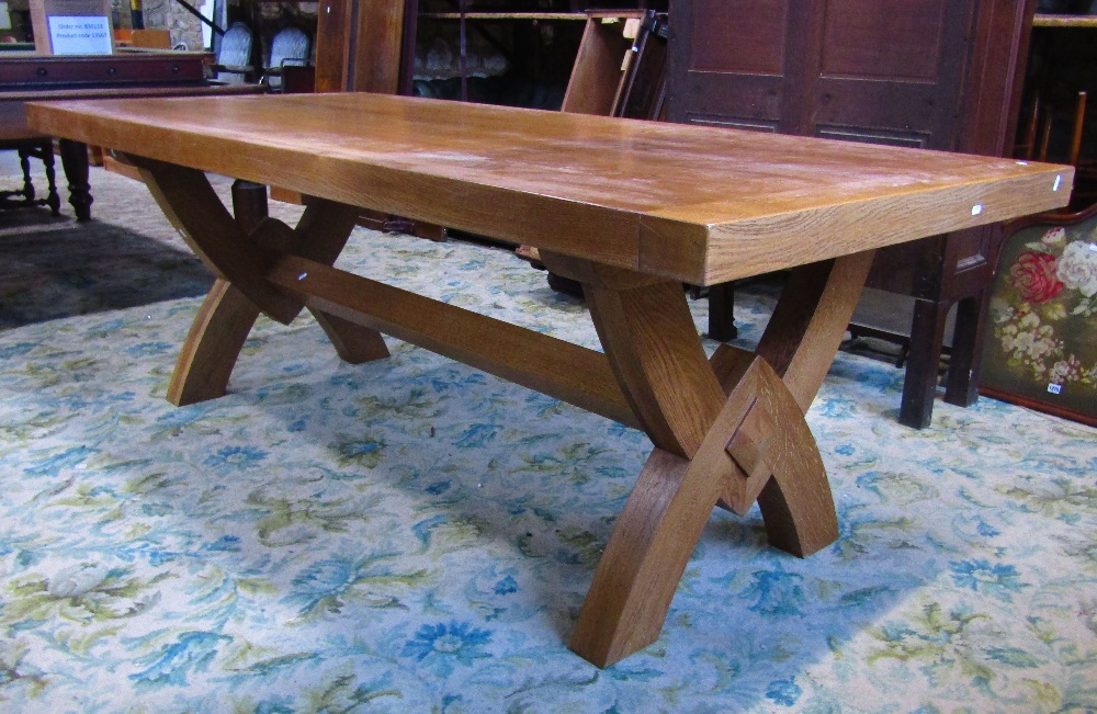 A good quality contemporary light oak dining table of rectangular form raised on X framed