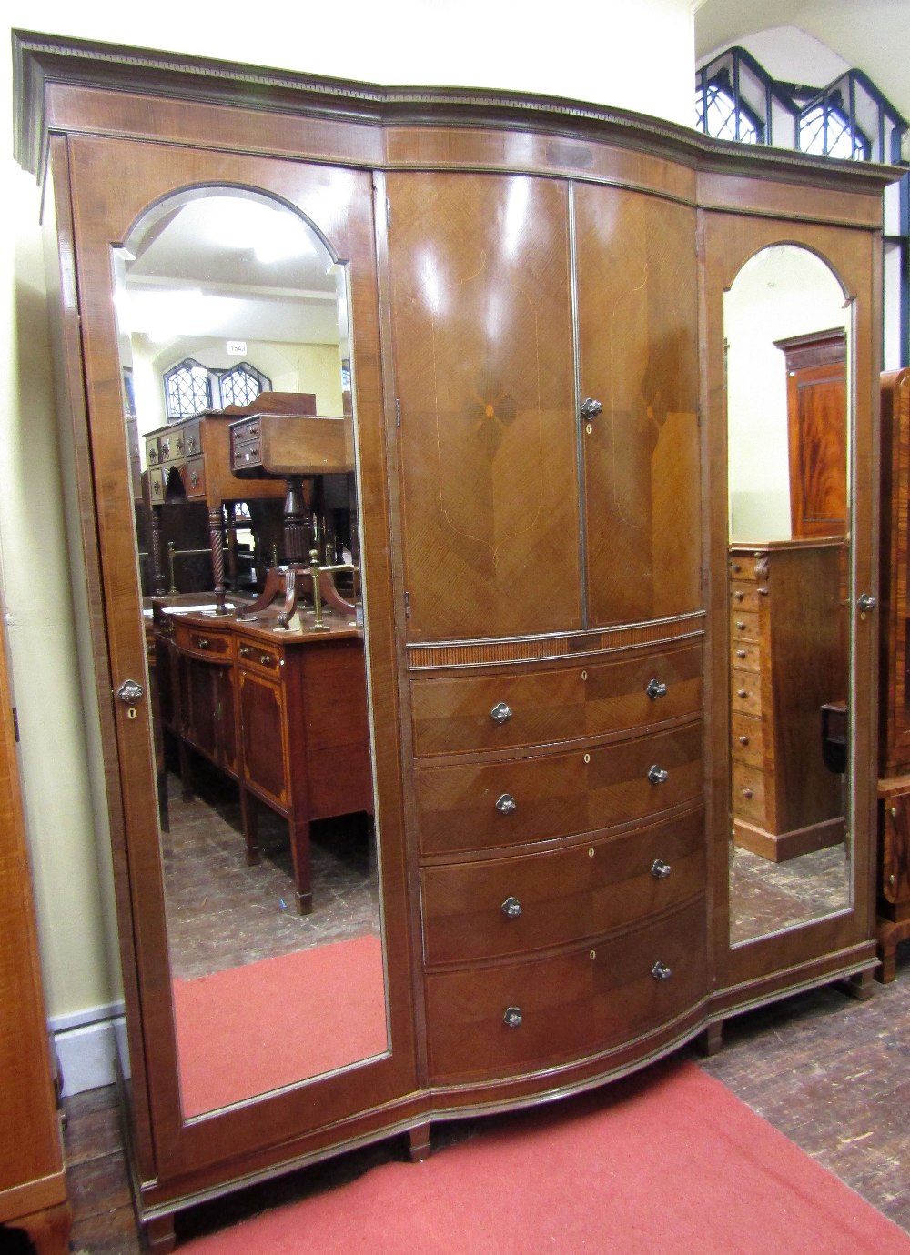 A substantial Edwardian mahogany triple wardrobe, the central section of bow-fronted outline, fitted