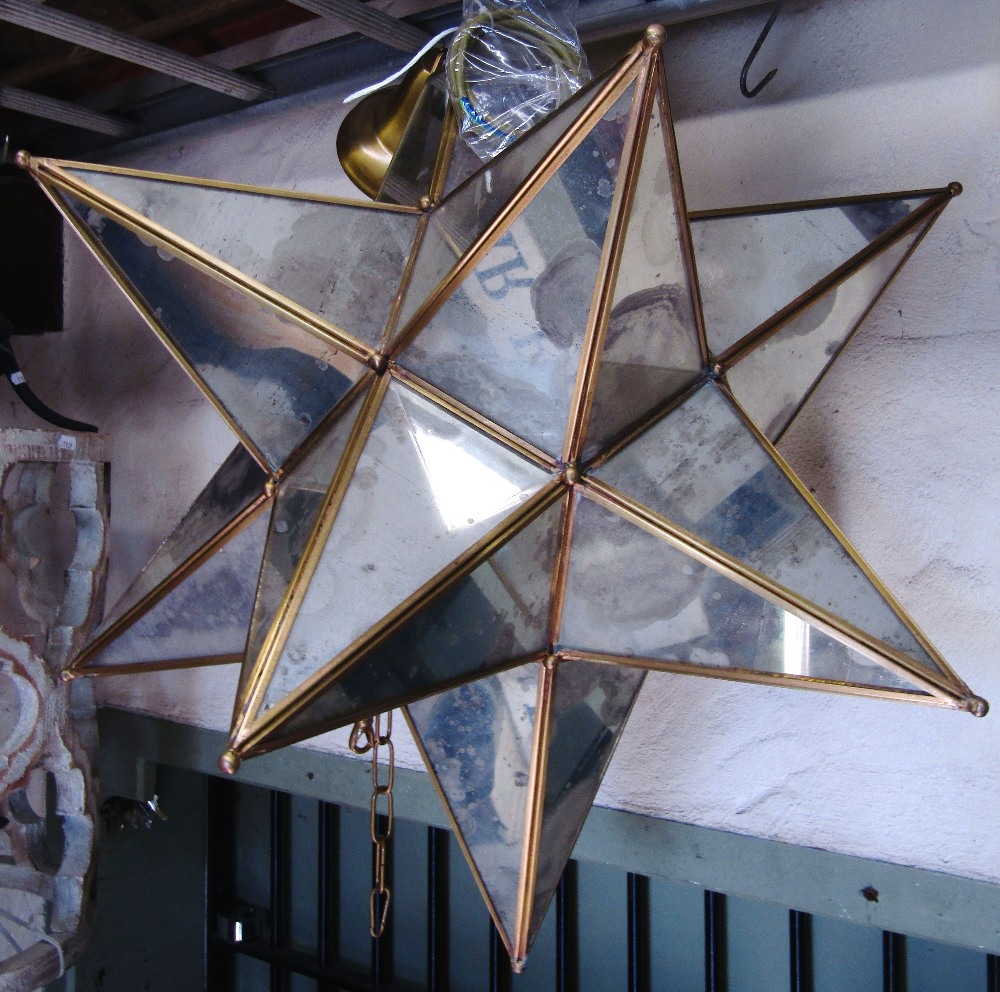 A contemporary star cluster shaped hanging ceiling light with segmented mirror panels