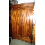 A 19th century walnut armoire enclosed by a pair of rectangular moulded panelled doors raised on