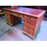 A reproduction Georgian style stripped pine, kneehole, twin pedestal writing desk, with inset
