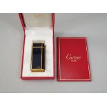 A Cartier cigarette lighter with dark blue enamelled panels Ref972555T with original presentation