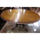 An early Victorian rosewood loo table, the top of oval form with carved and repeating floral borders