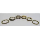 Six 9ct rings; four eternity rings set with white stones and two wedding rings to include a tri-