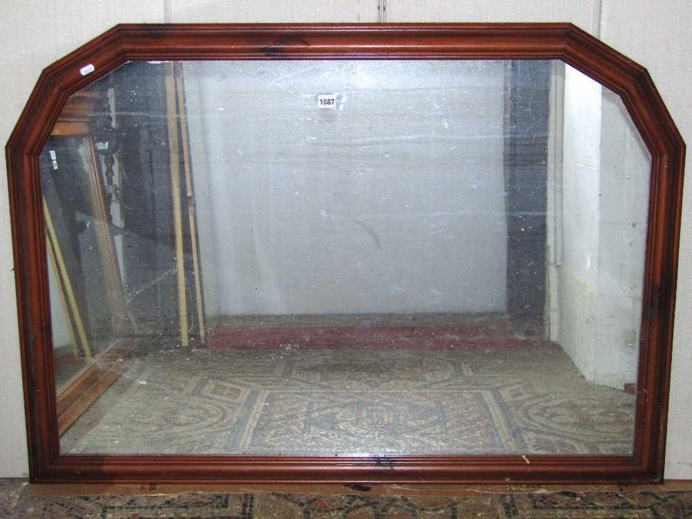 An overmantle mirror of rectangular form with moulded stained pine and canted frame, 125 cm x 88 cm